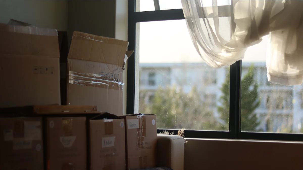 Cartons de déménagement empilés près d'une fenêtre dans un logement